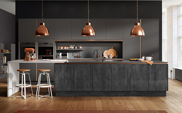 a dark, sleek kitchen with an island, slate textured units and bronze handing lights